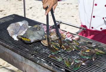 grilling seafood assortment of fish, shells of molluscs