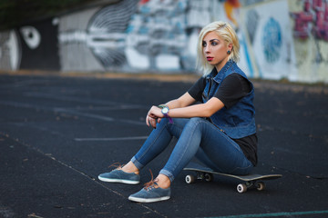 Outdoor lifestyle portrait of pretty young girl, wearing in hipster swag style on urban background with graffiti.