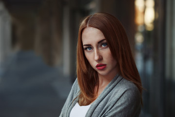 Beautiful redhair young woman in casual closes in urban background. Fashion Photo