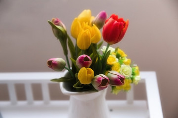 vase of red and yellow tulips on table