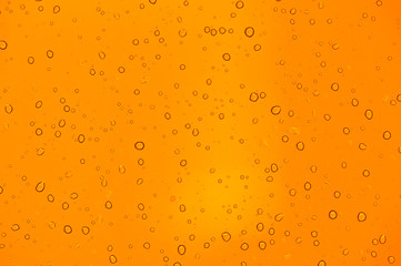 abstract orange background with raindrops on glass