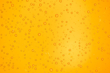abstract yellow background with raindrops on glass