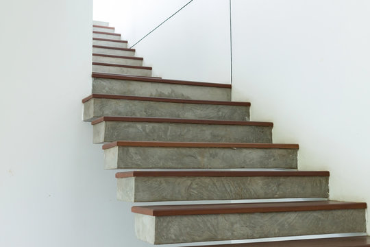 cement and wood staircase on white mortar wall