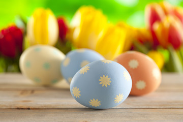Fototapeta na wymiar Colorful Easter eggs and fresh tulips