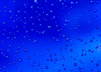 abstract blue background with raindrops on glass