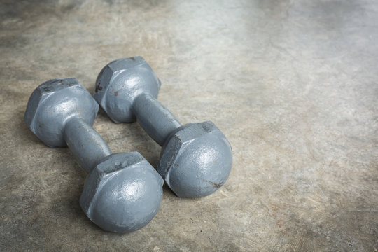 metal dumbbell on cement floor, fitness sport of bodybuilding