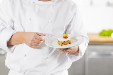 Obraz na płótnie Canvas Chef holding dessert cake with strawberry