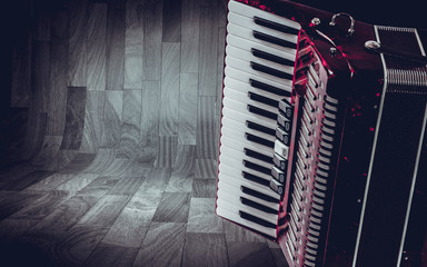 Part pink accordion on wooden grey background. Write text