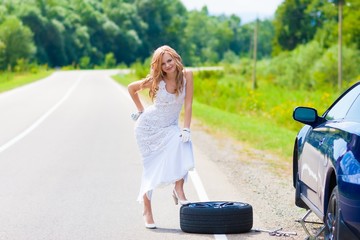 blond woman near car and wheel tire