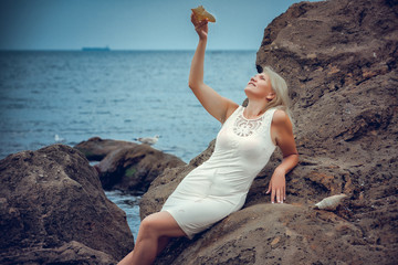 Fototapeta na wymiar Beautiful woman rock near the ocean