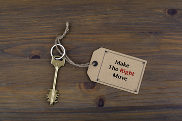 Key and a note on a wooden table with text - Make the Right Move