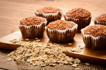 Oat muffins on brown wooden board.