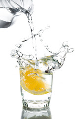 Pour water in glass with lemon