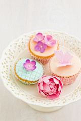 Cupcakes decorated with pink sugar flowers and a sugar butterfly