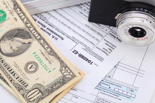 Money and camera on tax form background