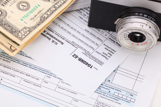 Money and camera on tax form background