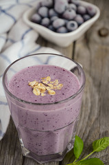 Blueberry and banana smoothie with oatmeal on the rustic wooden table. Selective focus.
