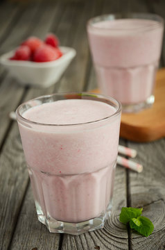 Strawberry and banana smoothie with oatmeal on the rustic wooden table. Selective focus.