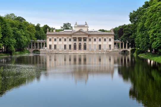 Palace in Lazienki Park in Warsaw reflected in the water and surrounded by trees. Poland.