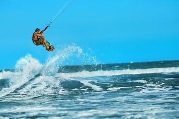 Recreational Water Sports Action. Healthy Man ( Surfer ) Kiteboarding ( Kite Surfing ) On Waves In Sea, Ocean. Extreme Sport. Summer Fun, Vacation. Active Lifestyle. Leisure Sporting Activity. Hobby