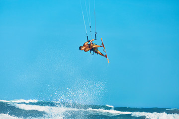 Recreational Water Sports Action. Healthy Man ( Surfer ) Kiteboarding ( Kite Surfing ) On Waves In Sea, Ocean. Extreme Sport. Summer Fun, Vacation. Active Lifestyle. Leisure Sporting Activity. Hobby