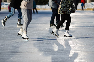 Closeup of group people on the  fugure skates outdoor in sunny spring day