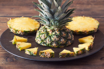 Pineapple fruit cut on wooden plate