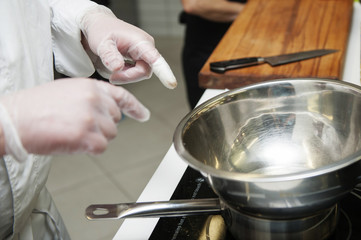Pans in the kitchen, the cook hands.