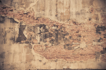 Old brick wall with cracked concrete pattern with sepia filter style