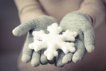 Female hands in mitten with snowflake