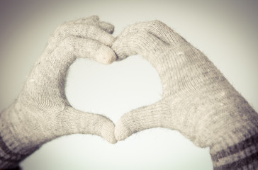 Woman's hands in mitten show heart shape - 104652521