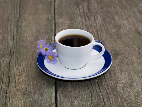 cup of coffee with a saucer decorated with flowers on a table