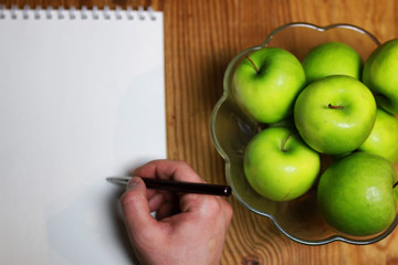 green apple in a glass bowl wooden background