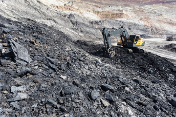 yellow backhoe work in coalmine