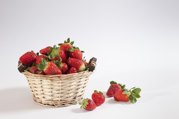 Fresh strawberries in and beside a container
