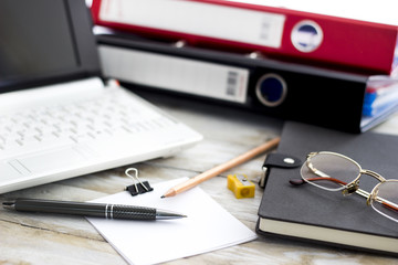Office workplace with laptop, folders and agenda on wood table