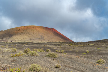 Fototapeta na wymiar Lanzarote Island one of seven Canary Islands in Atlantic Ocean. Extraordinary volcano landscape with black and reddish rocks, soils and rugged lava formations, for travel and nature blog, magazines