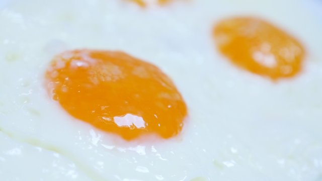 Deep fried on oil chicken egg yolks served slow tilt 4K 2160p 30fps UltraHD video - Tasty hen eggs fried fresh served food on plate 4K 3840X2160 UHD footage 