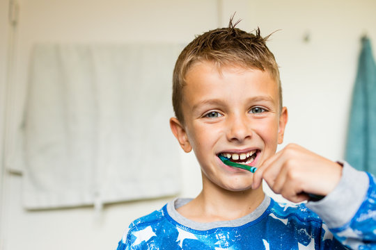 Young boy brushing his teeth with toothbrush