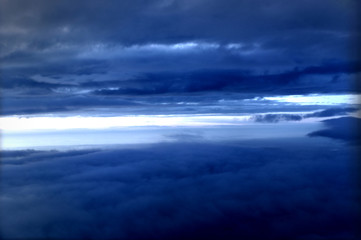 Fototapeta premium Sky background with clouds and copy space. Dramatice sky scene, view outside of an airplane window. 