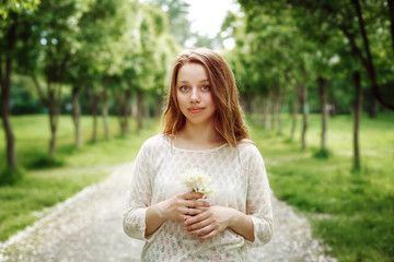 Young Woman Holding Flowers Outdoors