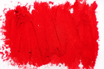 The texture of brush strokes of red lipstick. Background with dabs of red paint.
