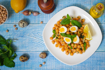 Mediterranean cuisine. Dish of chickpeas with mint, olive oil and lemon sauce on a wooden background