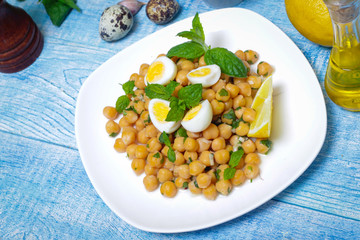 Mediterranean cuisine. Dish of chickpeas with mint, olive oil and lemon sauce on a wooden background