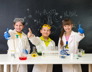 three little students on chemistry lesson in lab