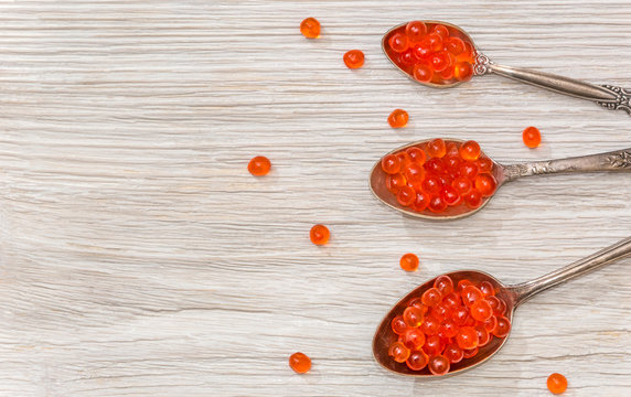 caviar in spoons on a wooden background