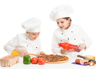 boy and girl in white uniform by the table with pizza