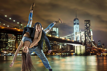 Young hip hop couple dancing, over urban background