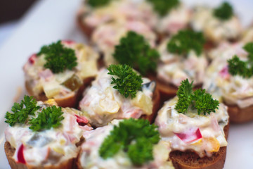 Beautifully decorated catering banquet table with different food snacks and appetizers with sandwich, caviar, fresh fruits on corporate christmas birthday party event or wedding celebration