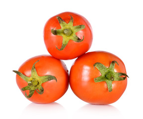 three fresh tomatoes with green leaves isolated on white backgro